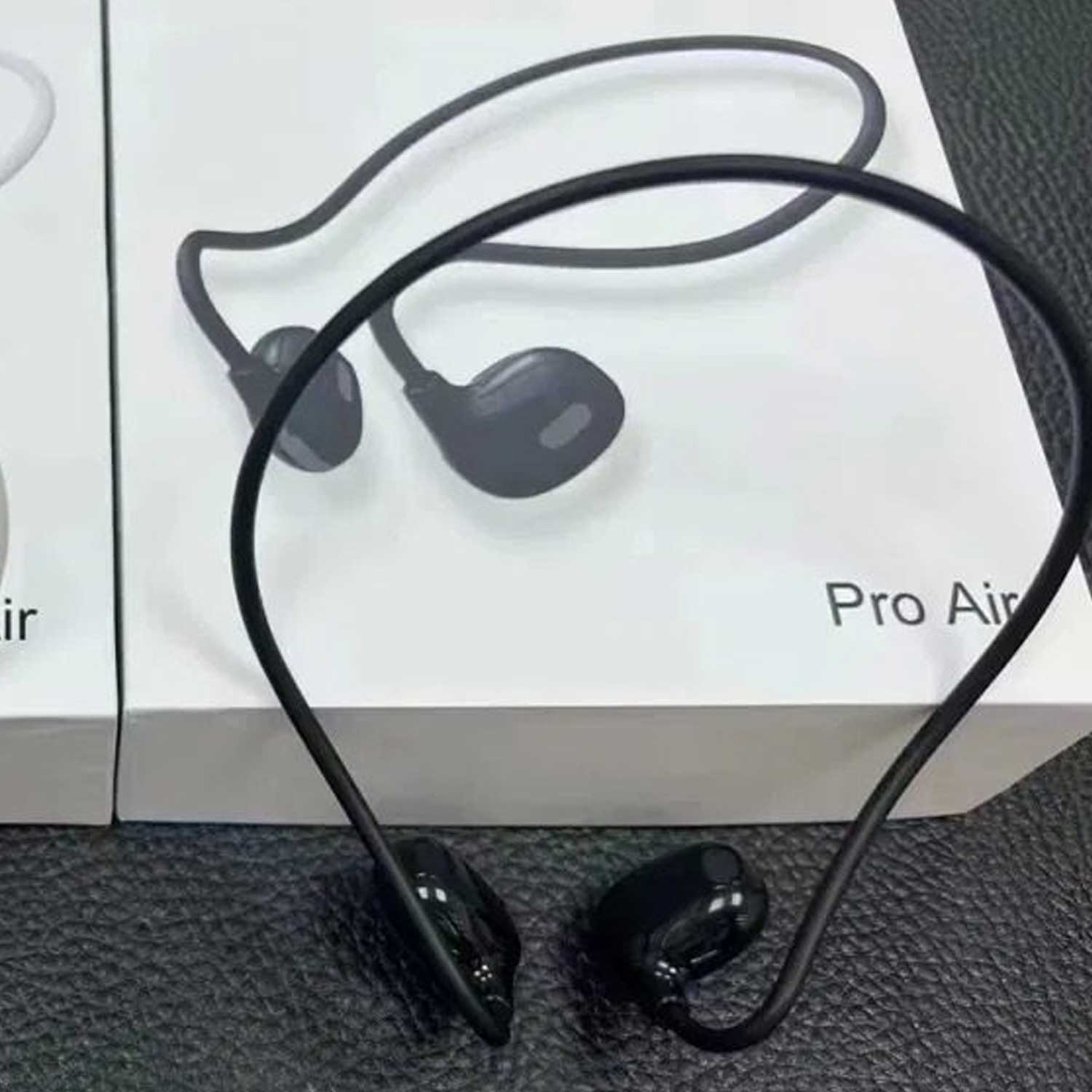 Black wireless earbuds with a cable on a textured surface