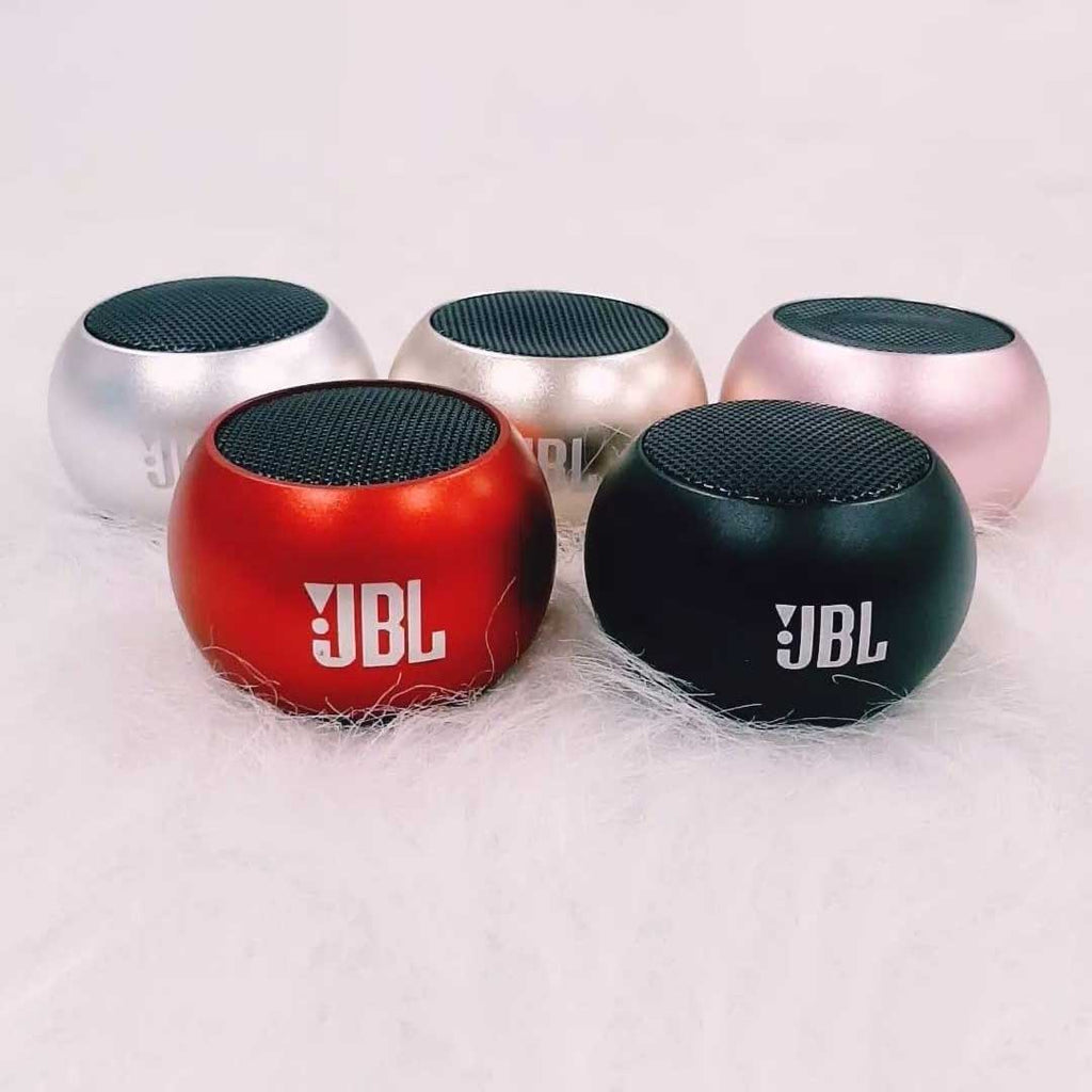 JBL M3 Mini portable speaker connected via Bluetooth to a smartphone playing music on a wooden desk